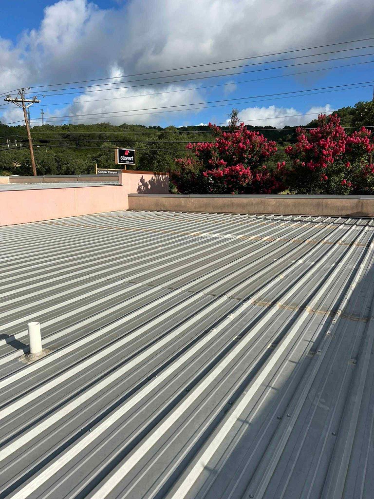 Commercial industrial corrugated metal roofing with perimeter parapet wall